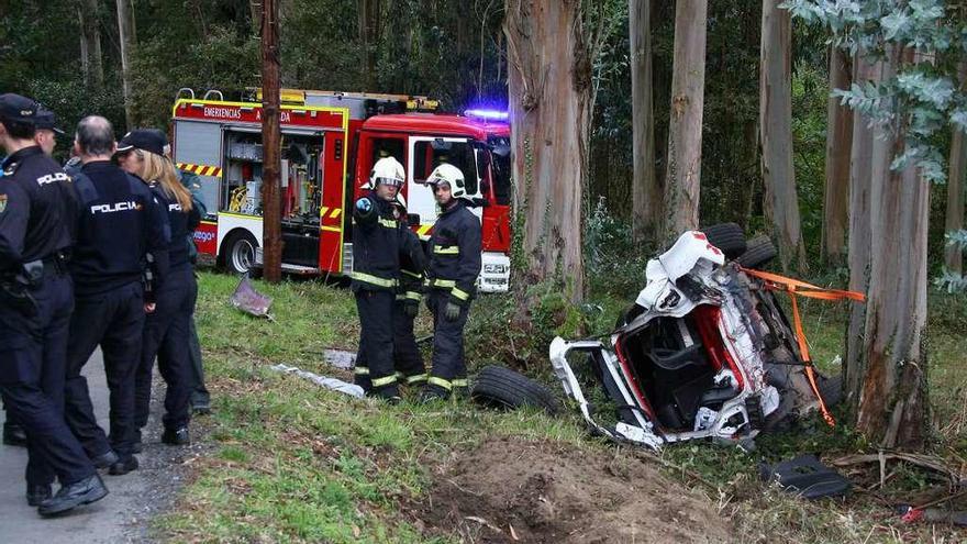 Policías nacionales y efectivos de Emerxencias, ayer, junto al coche siniestrado. // Bernabé / Adrián Rei