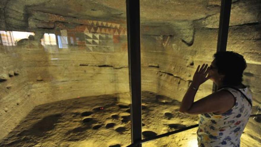 Una mujer observa las pinturas desde el cristal de protección en la Cueva Pintada de Gáldar. i  ANDRÉS CRUZ