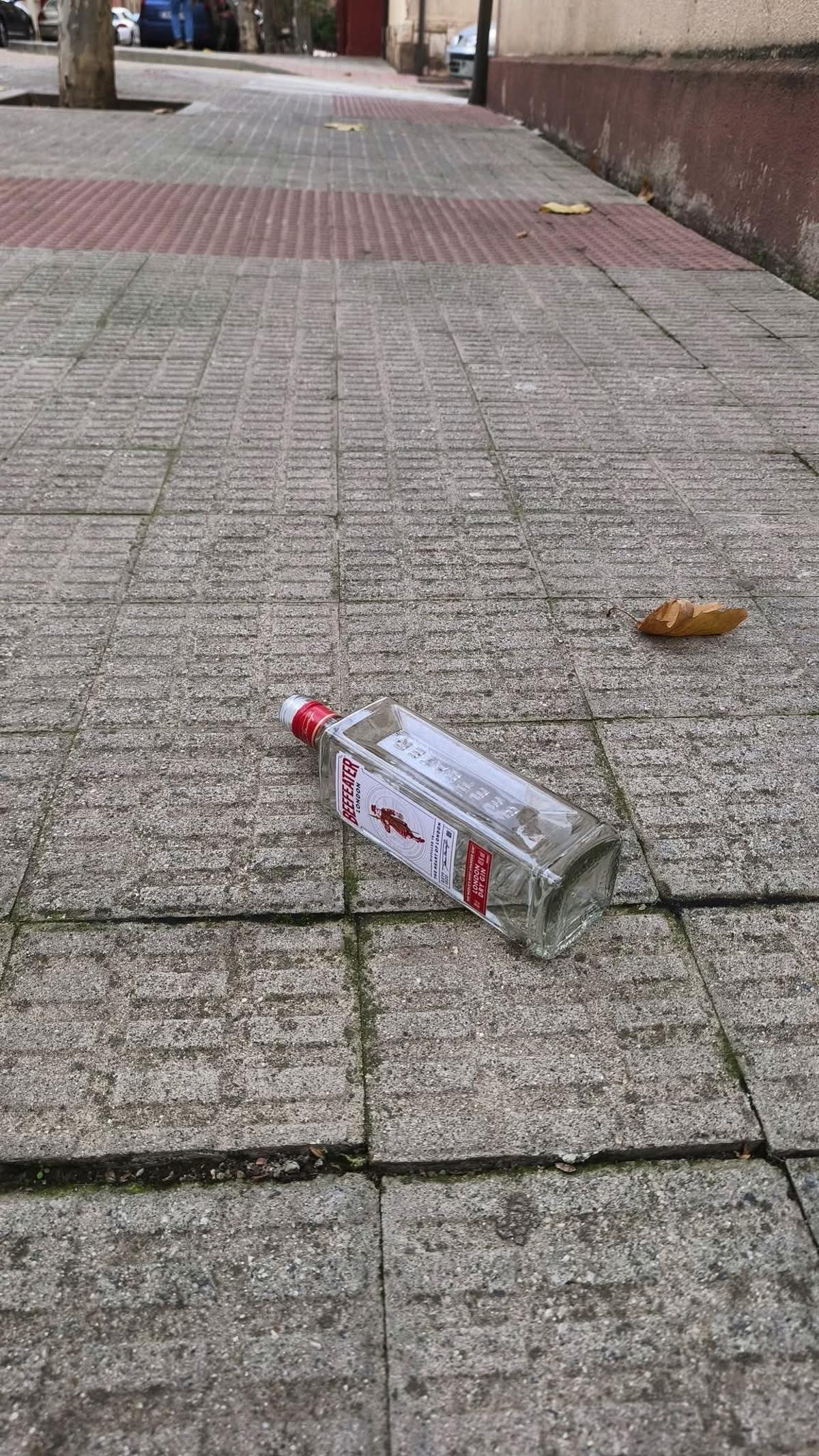 Botella de una marca conocida de alcohol en mitad de la acera