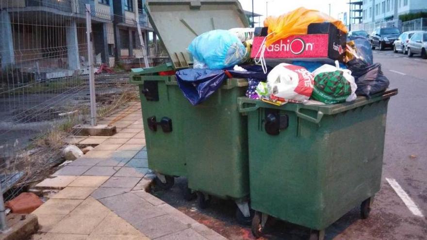 Contenedores de basura llenos en la calle Isla de la Erbosa.