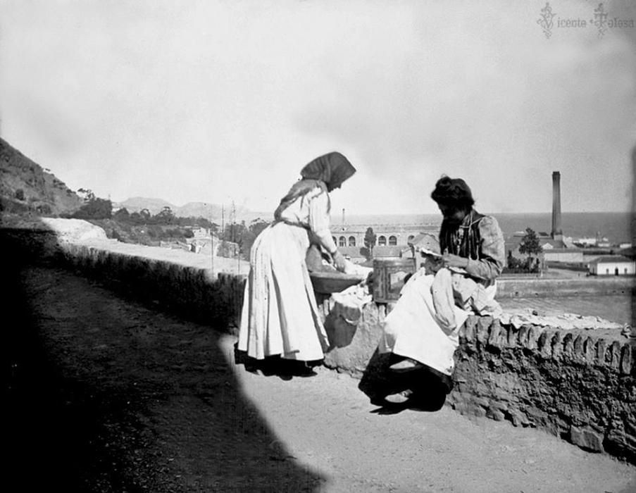 Una mujer lee una carta en La Coracha mientras la otra lava en un lebrillo, foto datada en 1903 y una de las que acompañan el libro.