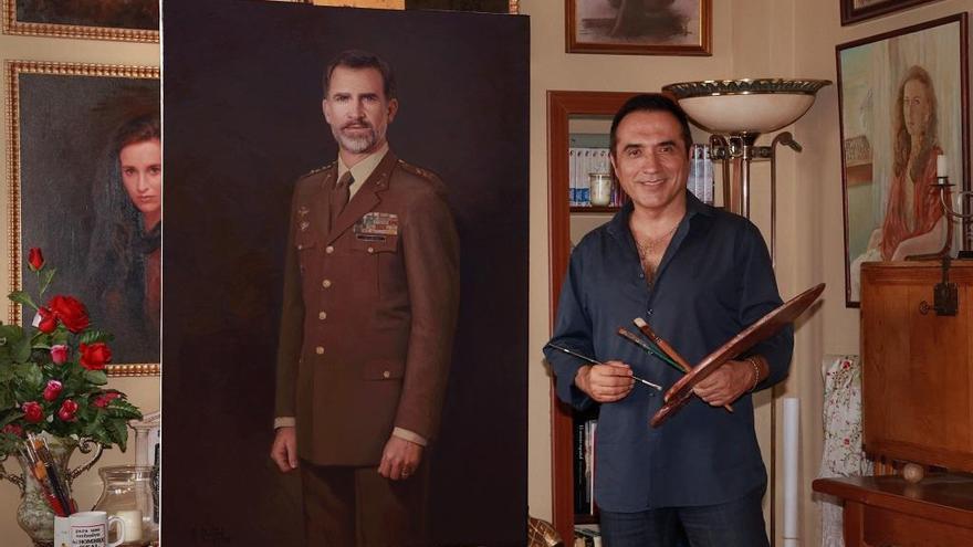 Antonio Montiel en su estudio, junto al retrato recién pintado del rey Felipe VI.