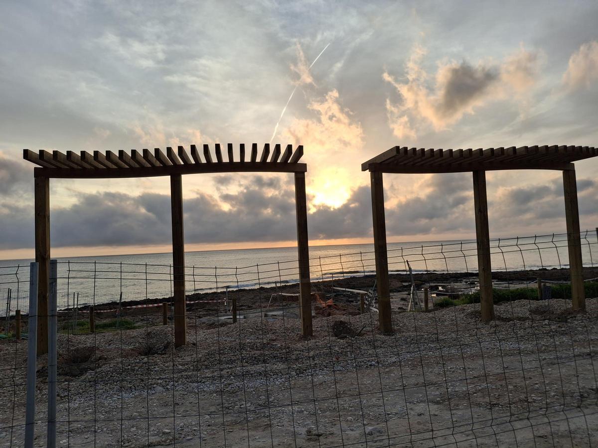 Un paisaje para enmarcar: el sol sale entre dos de estas estructuras de madera