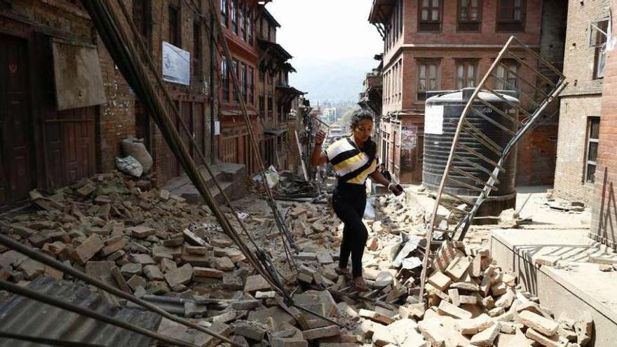 Una mujer camina entre los escombros en Bhaktapur (Nepal) un día después del terremoto. // Efe