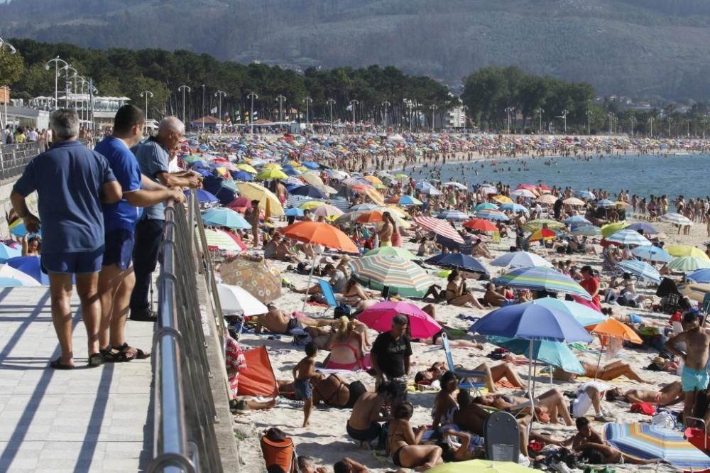 El buen tiempo anima a los bañistas en la playa de Samil