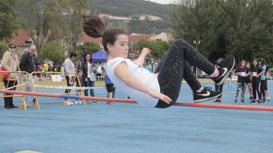 Una de las alumnas compitiendo en la prueba de salto de altura en A Xunqueira. // Santos Álvarez