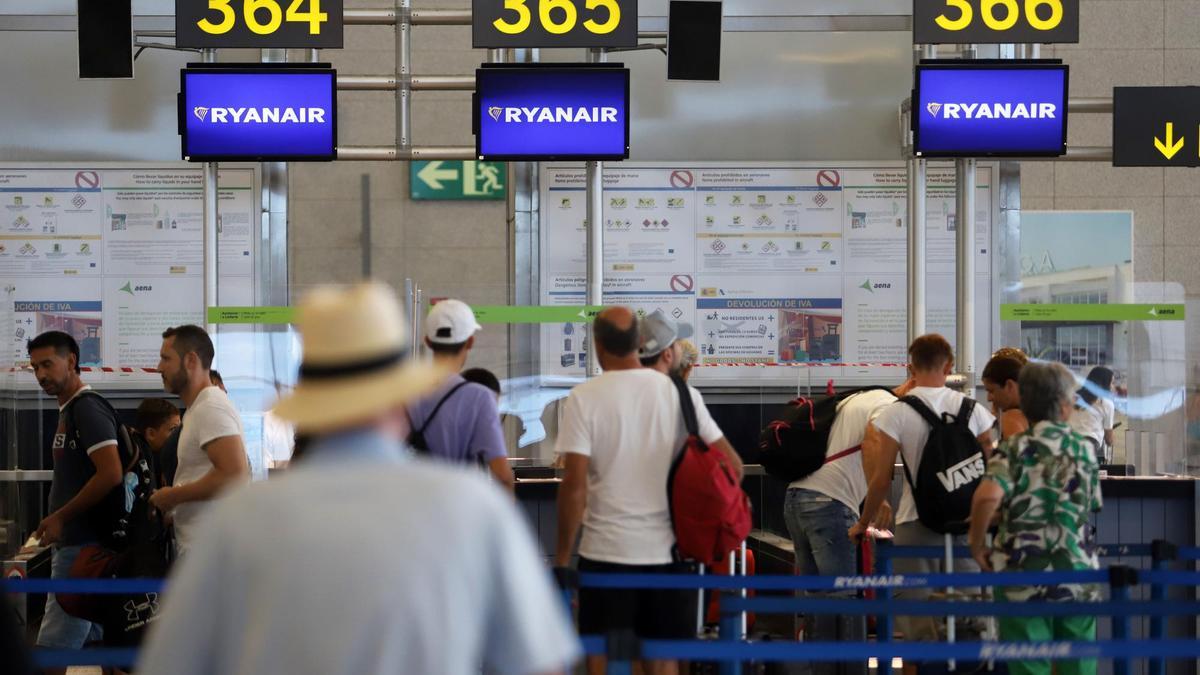 Turistas hacen colas en los puestos de embarque de Ryanair, en el Aeropuerto Costa del Sol.