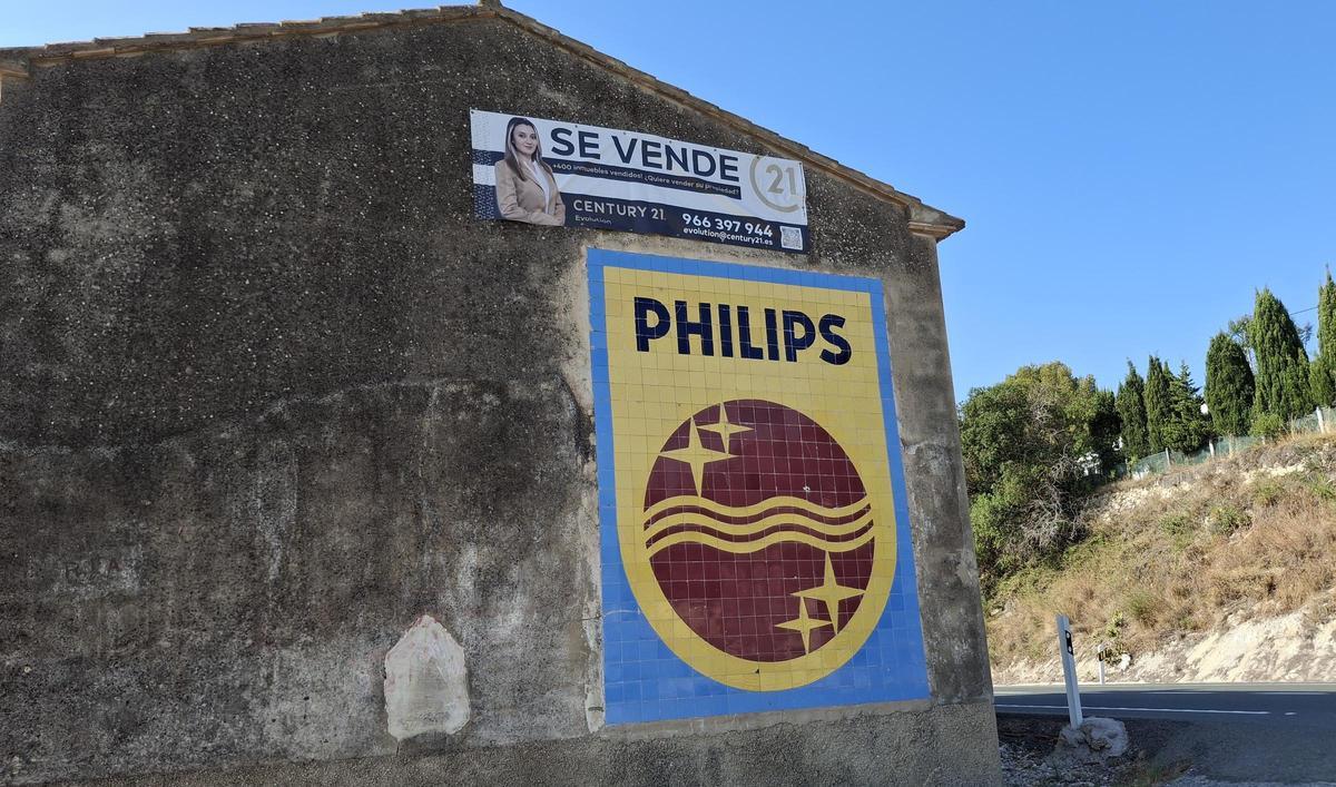 Los dos anuncios: el histórico de Philips, protegido como Bien de Relevancia, y el de "se vende"