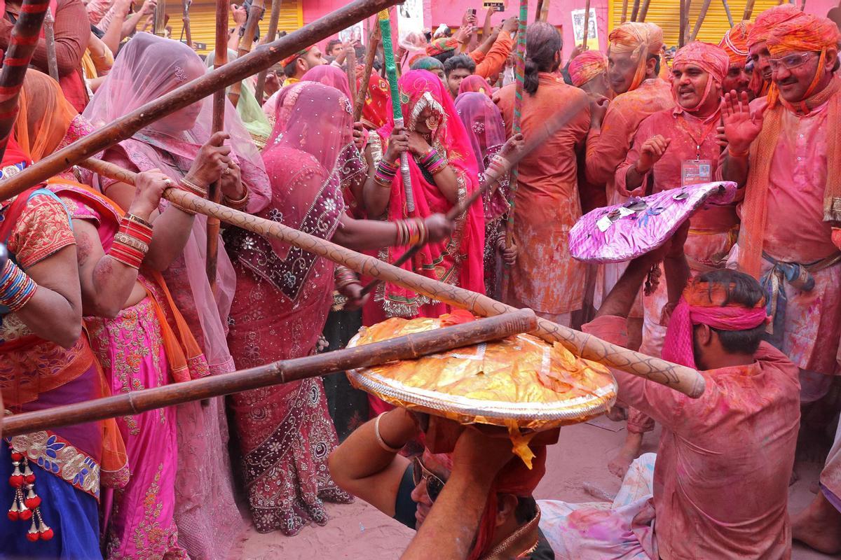 Los devotos hindúes participan en el festival religioso de Holi dentro de un templo en la aldea de Nandgaon, en el estado de Uttar Pradesh, India.