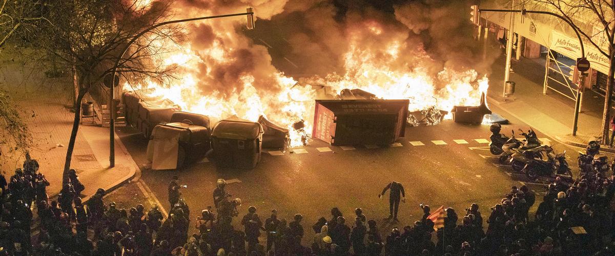 Contenedores ardiendo en la confluencia de las calles Aragó y Bailén de Barcelona en el tercer día de protestas por el encarcelamiento de Pablo Hasél.