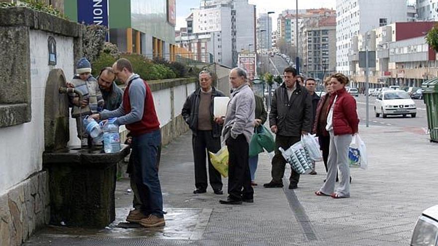 Vecinos hacen cola para llenar garrafas en la fuente de Travesía.