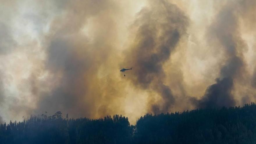 Un helicóptero arroja agua sobre uno de los focos del incendio forestal en Portugal.