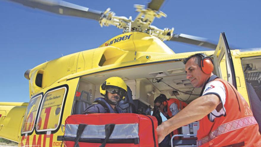 El piloto Carlos Martínez, la enfermera Cristina Rodríguez y el médico Ángel Crespo cargan el material en el helicóptero.