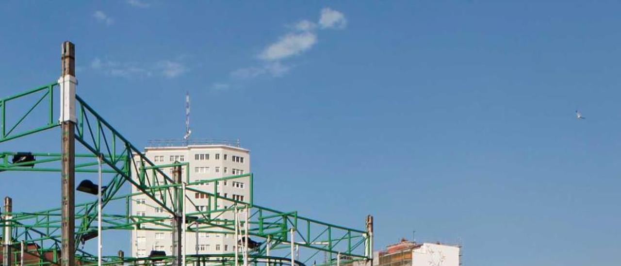 Un paseante, observando ayer la instalación de atracciones en la zona.