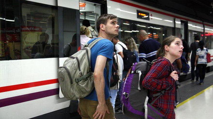 Dos usuaris consulten els horaris de Renfe