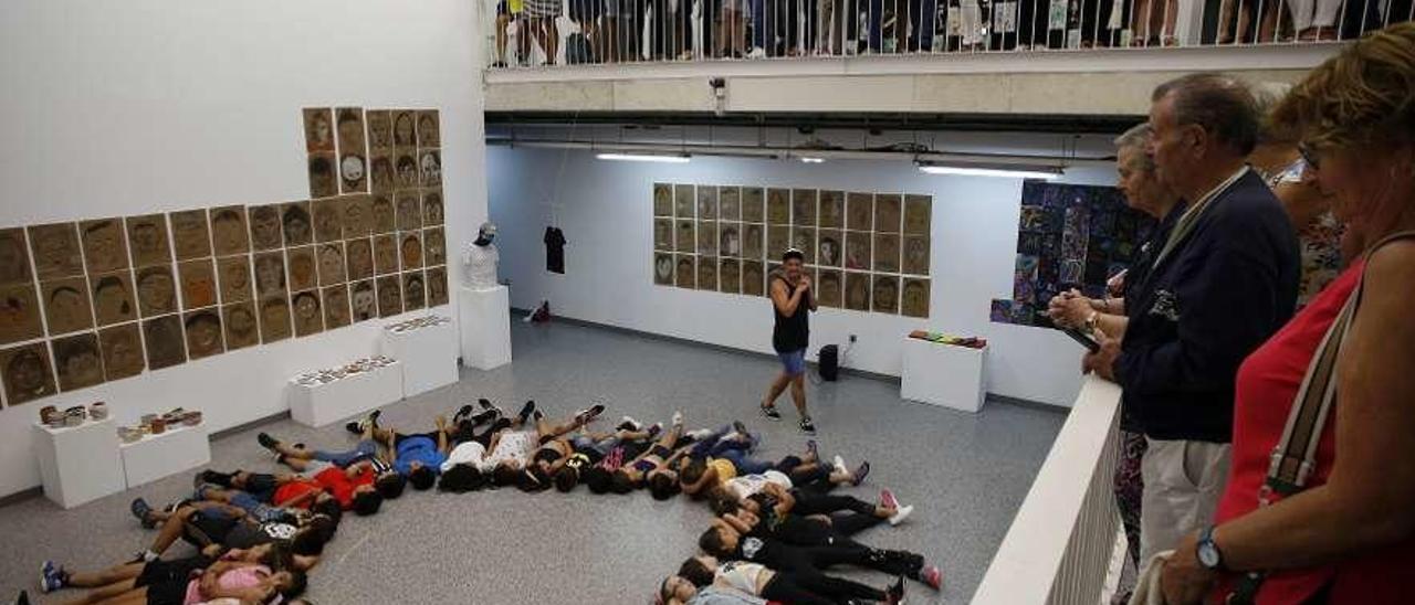 Todos los niños participantes en el campus artístico, tumbados en el suelo antes de comenzar el acto de clausura, ayer, en la Factoría Cultural.