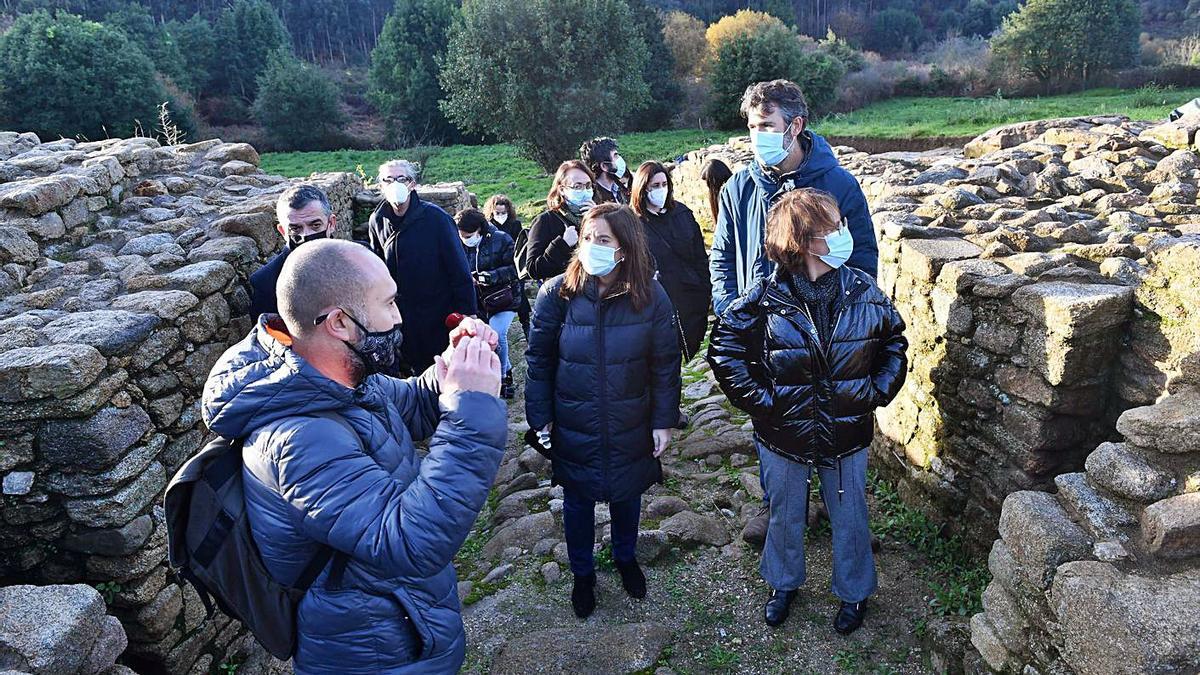 La comitiva municipal recibe explicaciones durante su visita al castro de Elviña.   | // VÍCTOR ECHAVE