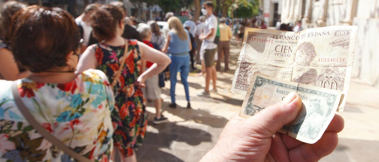 Un ciudadano muestra los billetes de pesetas que quiere cambiar en el Banco de España.