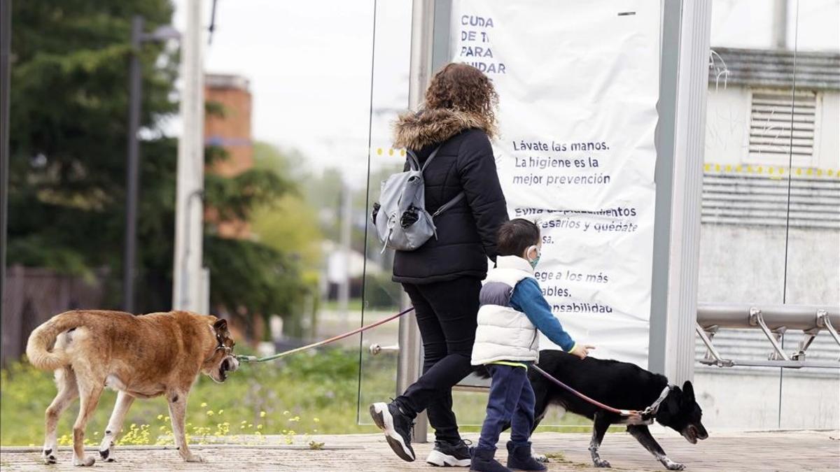 Una mujer pasea con su hijo y sus perros en Boadilla del Monte, el 16 de abril