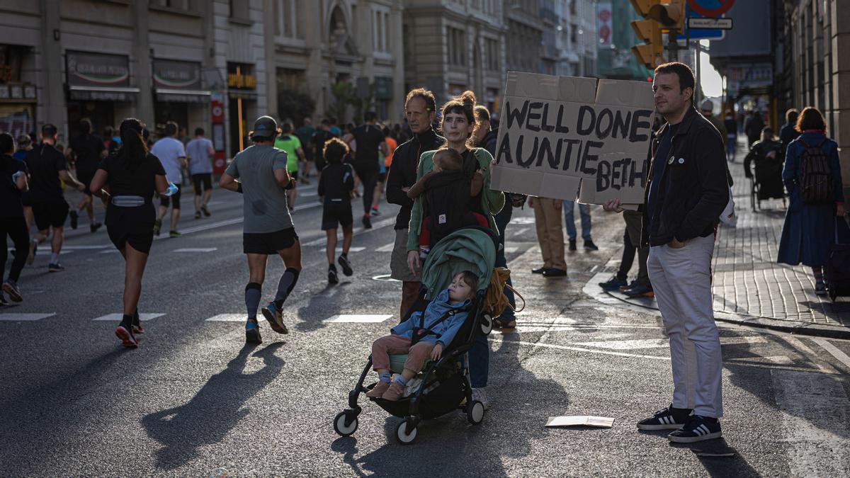 Una familia anima a los corredores, que bajan por Via Laietana para cubrir el último kilómetro de la carrera