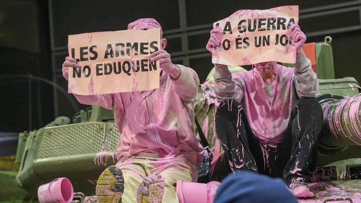 Unos pacifistas rocían pintura rosa sobre una tanqueta en Expojove: &quot;Las armas no educan&quot;.