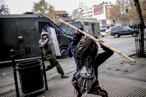 Student clashes with riot police during a demonstration against the government demanding for changes in the state education system in Santiago