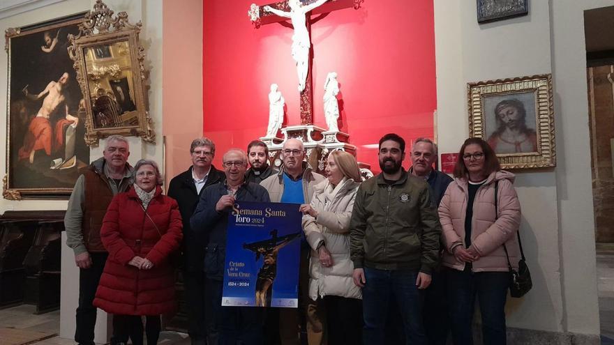 Miembros de la Junta Pro-Semana Santa posan con el cartel anunciador de esta edición. | C.T.