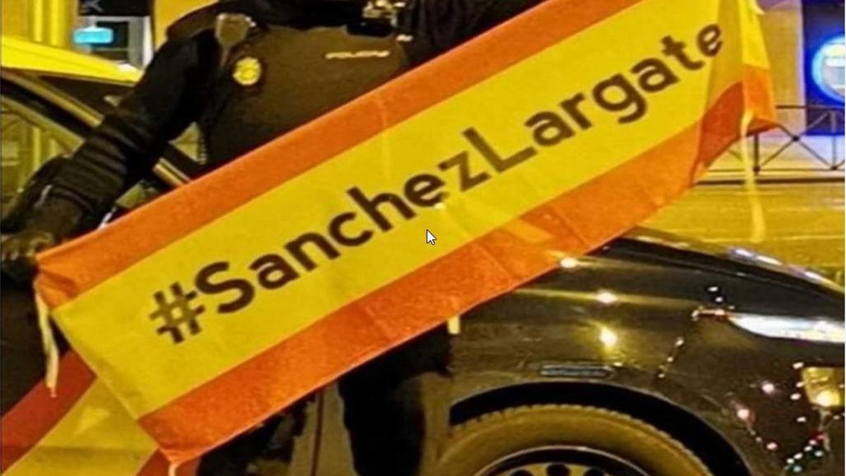 Un supuesto policía uniformado junto a su coche patrulla, en una imagen difundida este viernes en X.