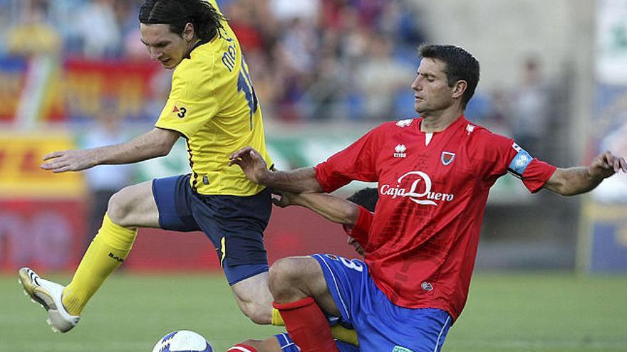 intensidad. El defensa del Numancia, César Palacios, intenta robarle el balón al delantero argentino del FC Barcelona, Lionel Messi.