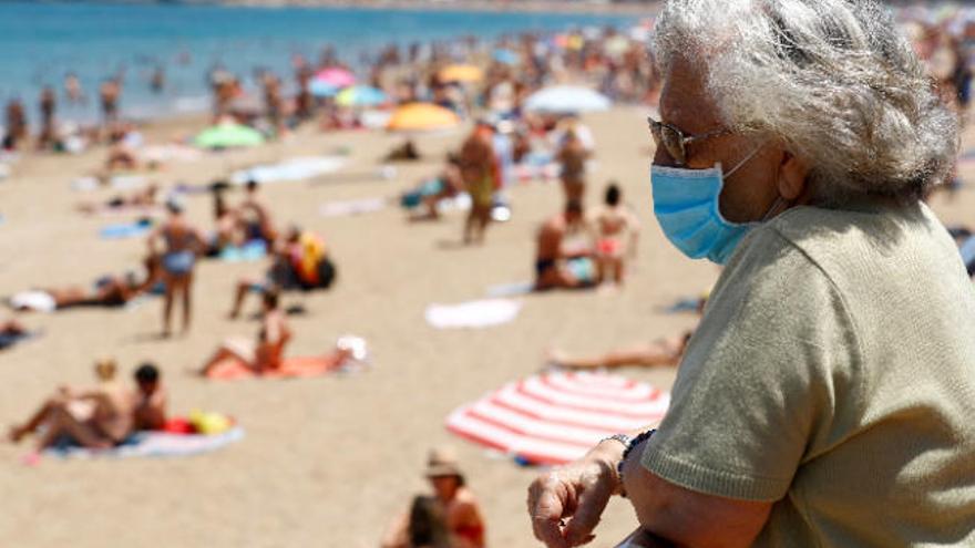 Una mujer protegida con mascarilla, en el paseo de Las Canteras.