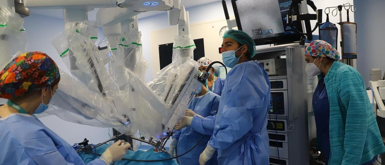 Un grupo de cirujanos prepara los brazos robóticos de Da Vinci en el hospital Reina Sofía.