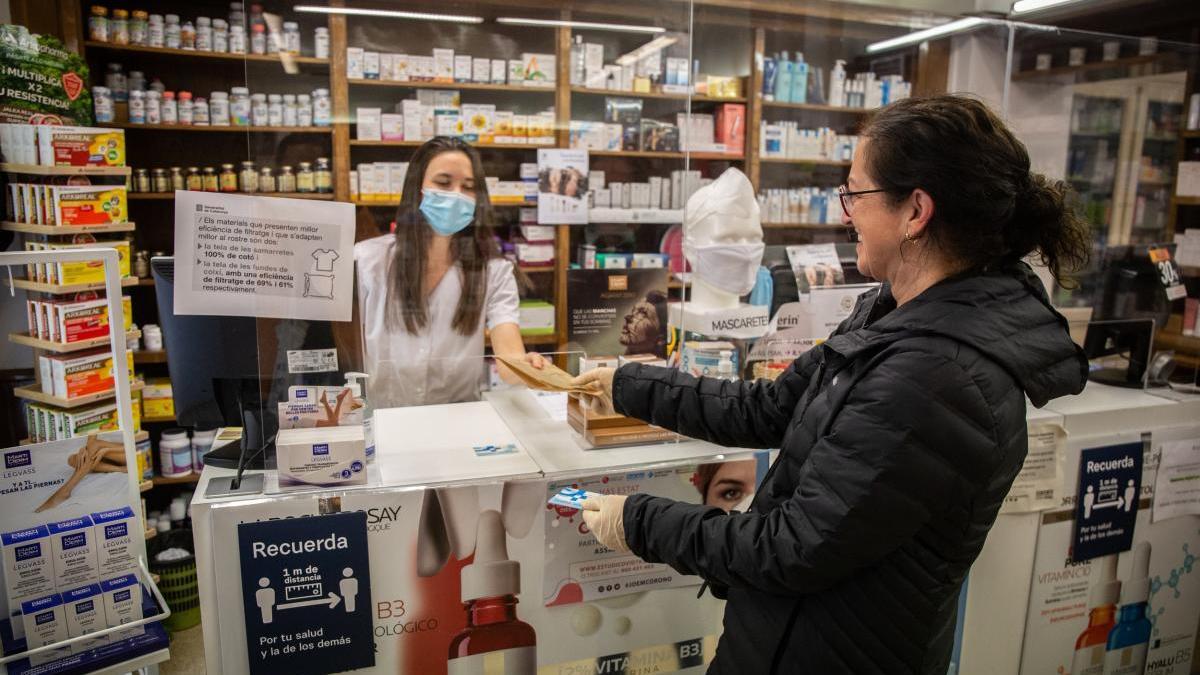 Una mujer abona unos medicamentos en su farmacia.