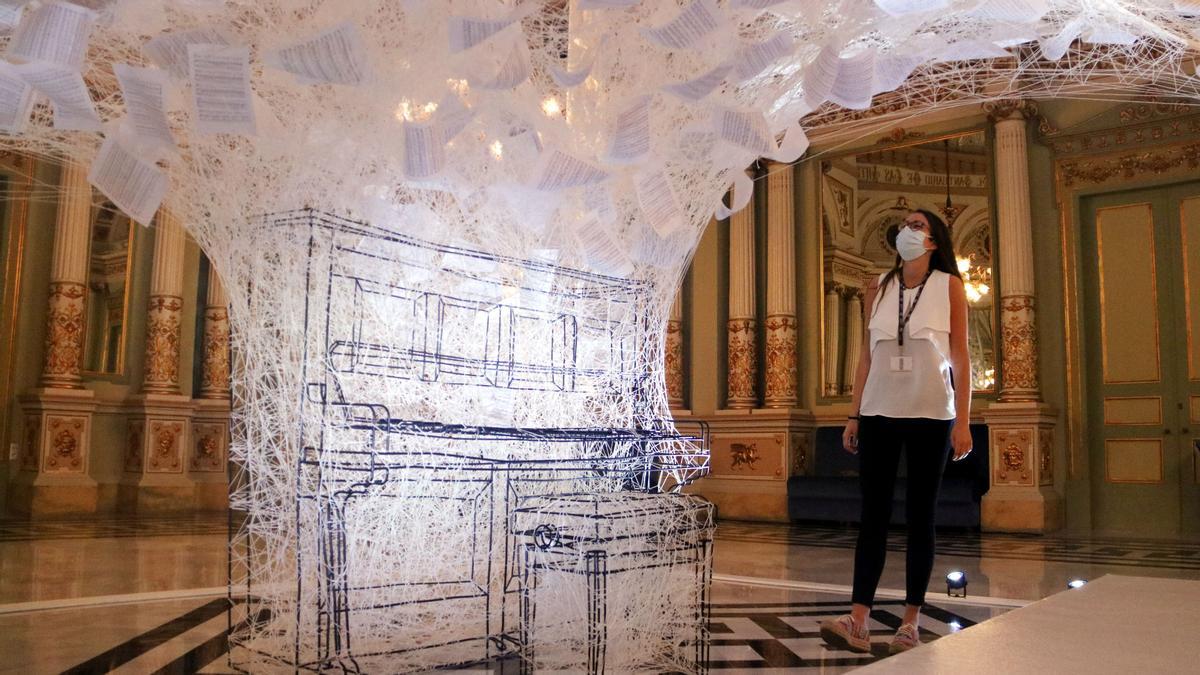 Una mujer observa la instalación 'Last hope', de Chiharu Shiota, en el Saló dels Miralls del Liceu, este lunes.