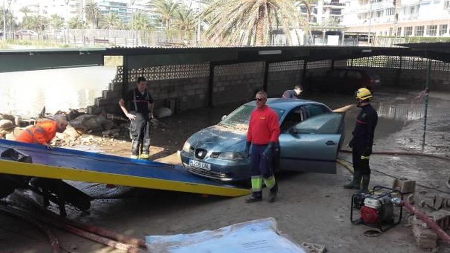 Una grúa retira uno de los coches afectados por las inundaciones en los apartamentos Playa.