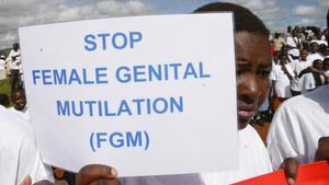 Una mujer sostiene una cartel contra la Mutilación Genital Femenina en una protesta en Kenia.