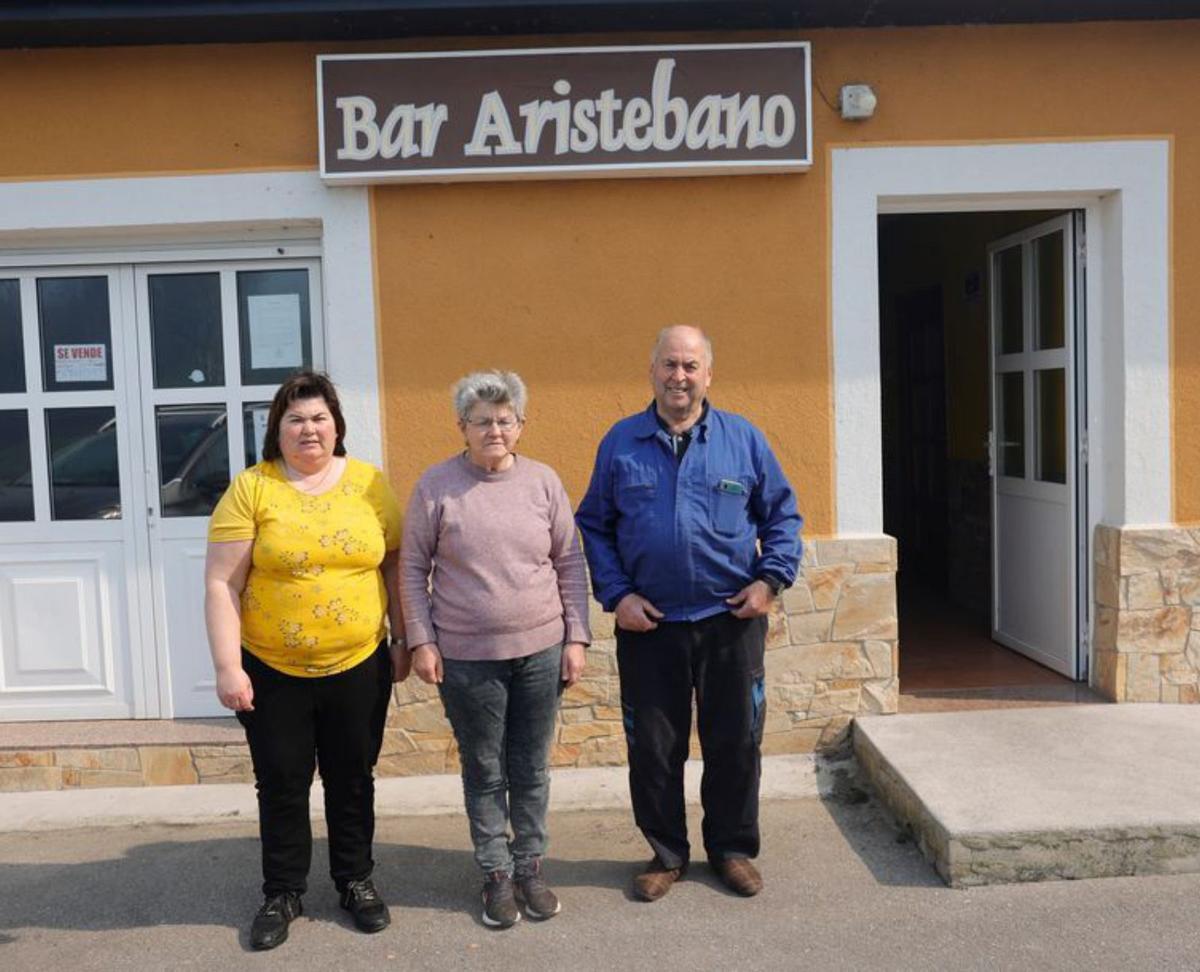 A la izquierda, de izquierda a derecha, Elvira Verdasco, Ana García y Amador Verdasco, en el bar Aristébano. A la derecha, vista desde la parroquia de Aristébano. | Miki López