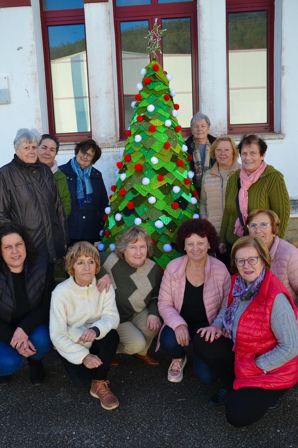 Otra imagen de las vecinas de Muñás con su árbol de Navidad de ganchillo, de algo más de dos metros.