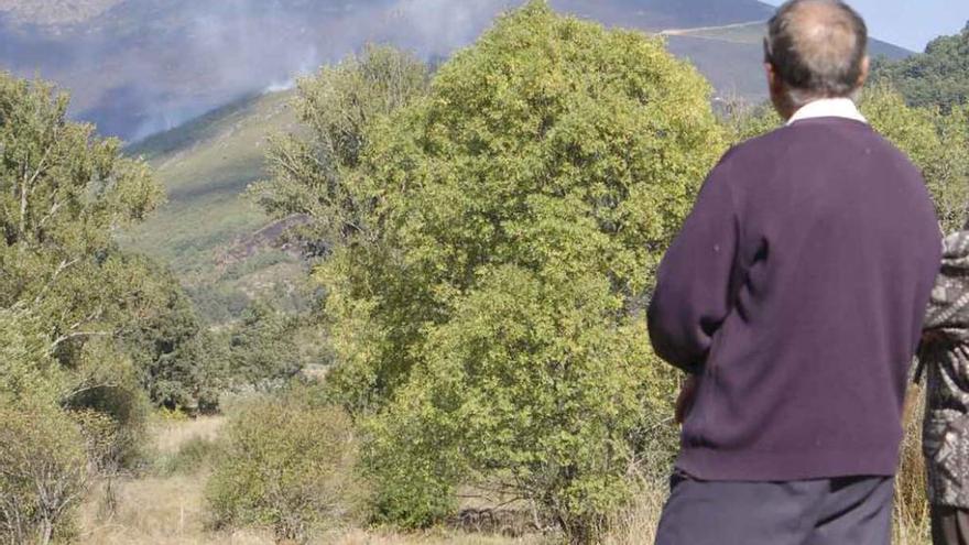 Dos personas observan el desarrollo de un incendio en la comarca de Sanabria.