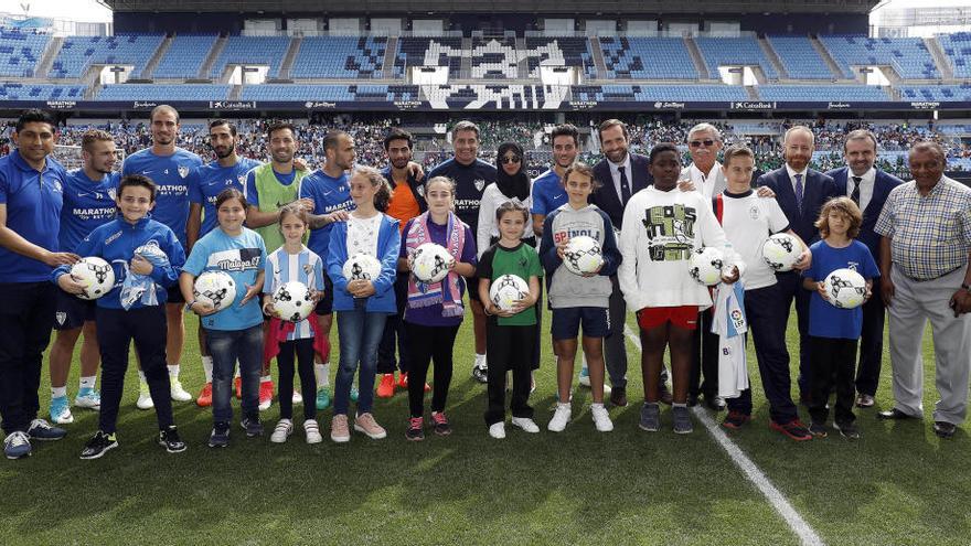 Representantes de los colegios, en el césped de La Rosaleda.