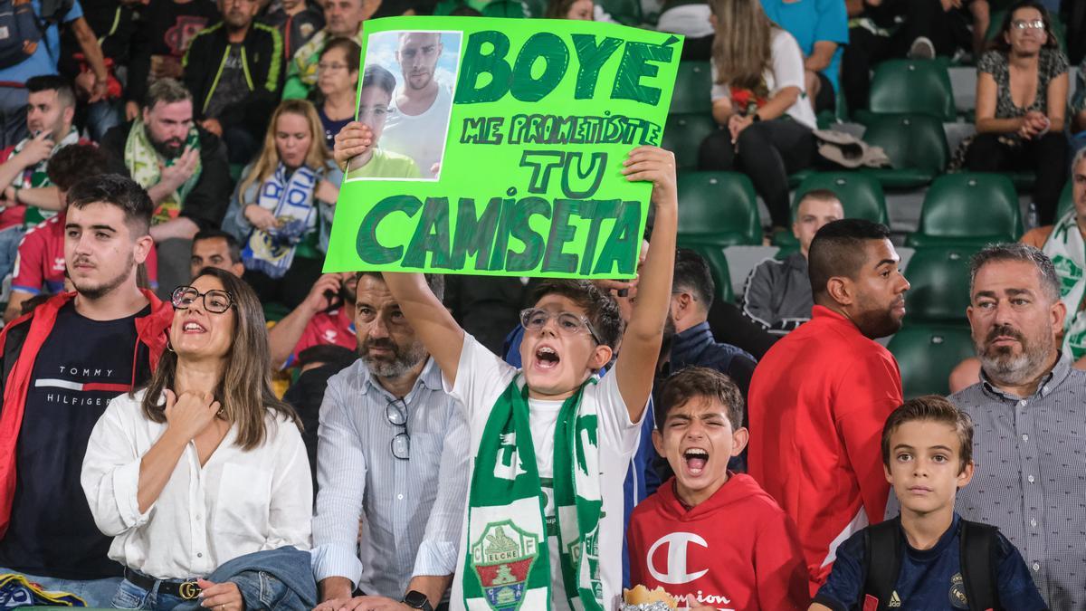 Un joven aficionado con una pancarta pidiendo la camiseta a Lucas Boyé