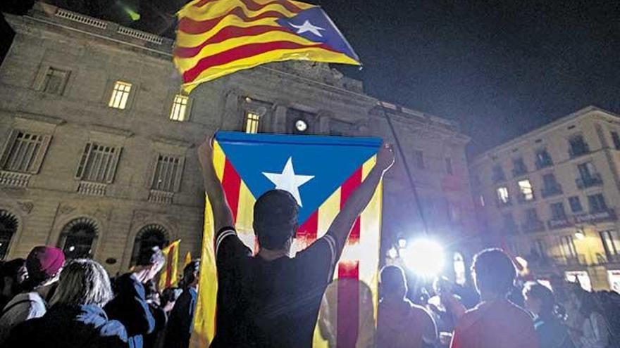 Un joven porta una estelada en la Plaza Sant Jaume de Barcelona.