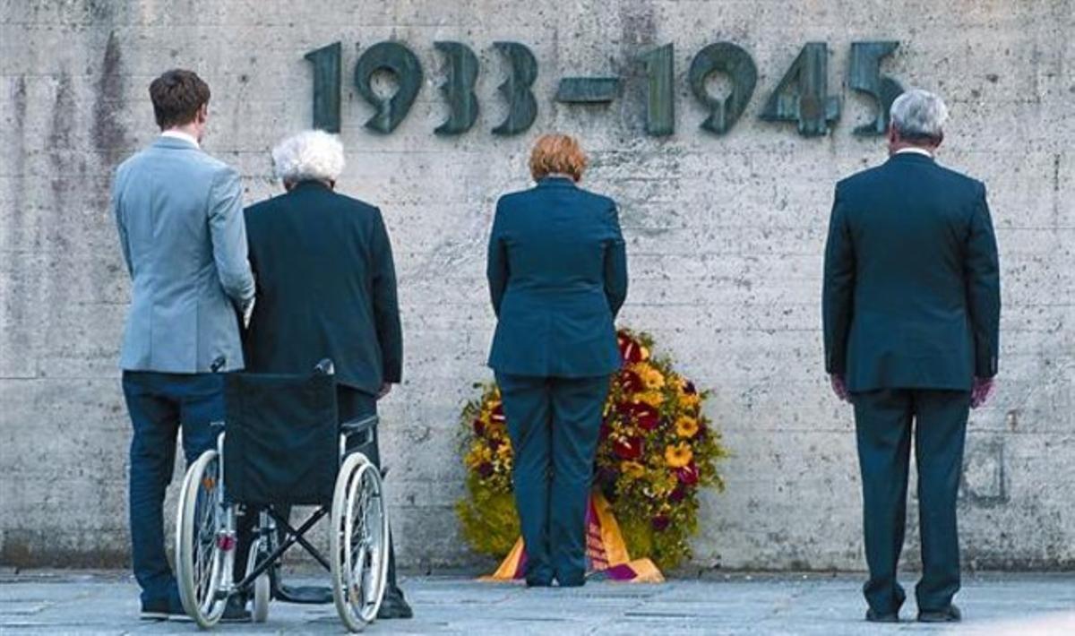 Ofrena 8 Merkel diposita una corona de flors a Dachau, juntament amb el ministre de Cultura bavarès (dreta) i un supervivent de l’Holocaust, ahir.