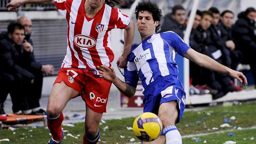 El defensa checho Tomas Ujfalusi (i), del Atlético de Madrid, y el centrocampista español Luque (d), del Málaga, persiguen el balón por el césped de La Rosaleda, donde han jugado el partido correspondiente a la vigésima jornada de liga. EFE/ Jorge Guerrero