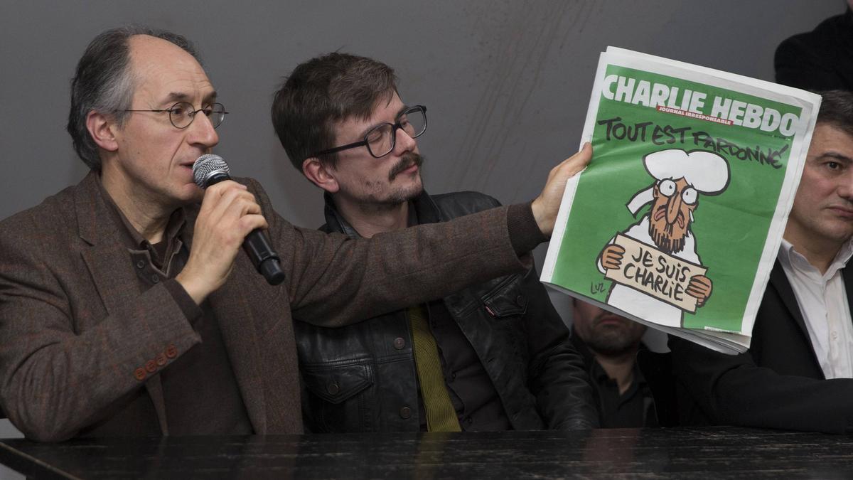 Gerard Briard, sostiene el especial de 'Charlie Hebdo' tras el atentado, en enero de 2015, ante la mirada de Luz, autor de la portada.