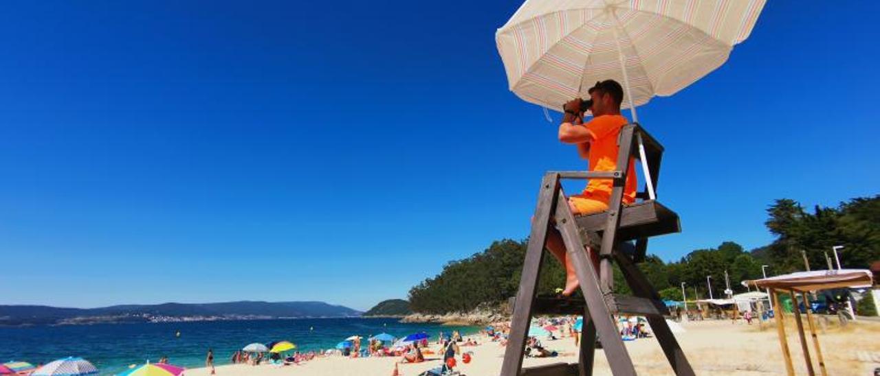 Un socorrista realiza labores de vigilancia en la playa de Portomaior, en Bueu. |   // SANTOS ÁLVAREZ