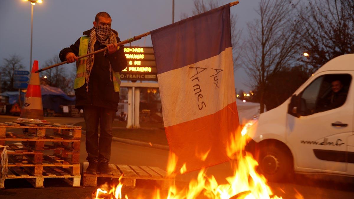 Francia aplaza la subida de impuestos a los carburantes por las protestas. En la imagen, un conductor francés protesta en la autopista A2 que lleva de París a Bruselas.   