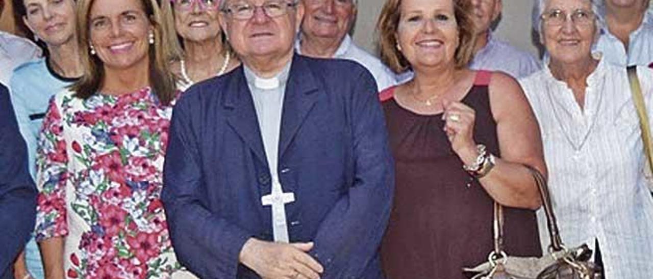 Valenzuela, a la izquierda del obispo, en la foto en la que aparece su exmarido al fondo a la derecha.