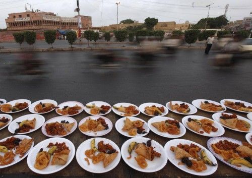 Se presentan platos de comida durante el mes sagrado de ayuno del Ramadán, a lo largo de una carretera en Karachi, Pakistán.