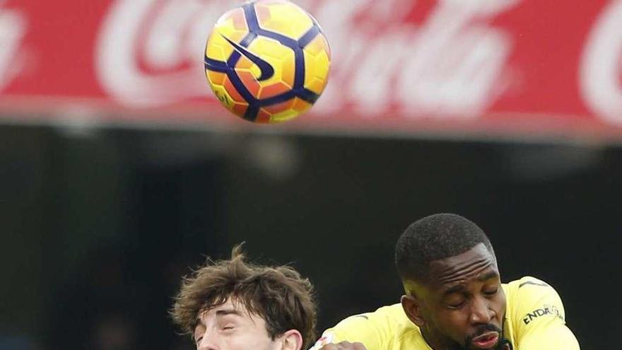 Odriozola, de la Real Sociedad, y Bakambu, del Villarreal, saltan por un balón. // Juan Herrero