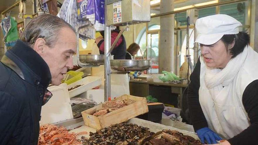 Un cliente ojea el marisco a la venta en el Mercado. // Rafa Vázquez